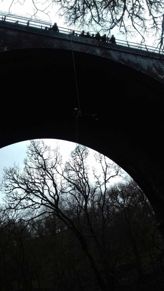Silhouettes of people watching from the top of viaduct